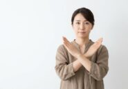 両腕でバツ印を作る母親
