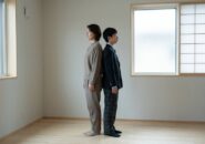 背中合わせに立つ母親と制服の中学生の息子
