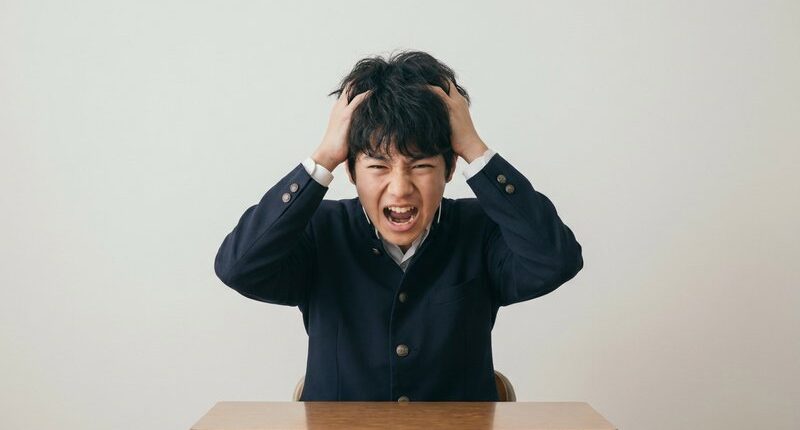 頭を抱えて叫ぶ男子中学生、かんしゃく