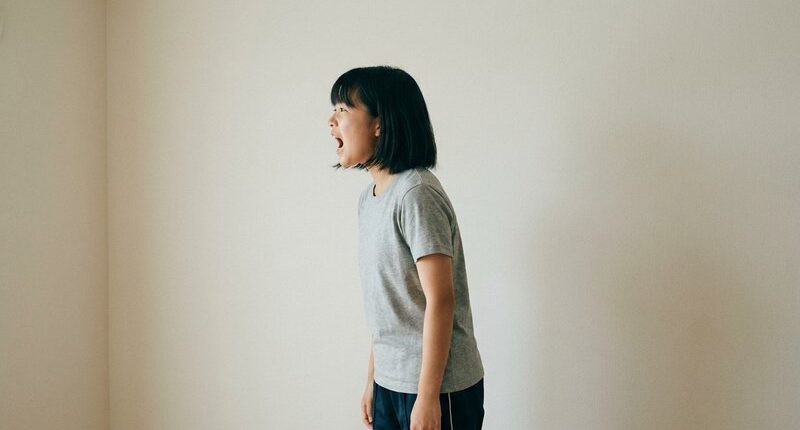 横を向いて大声で叫ぶ女子中学生